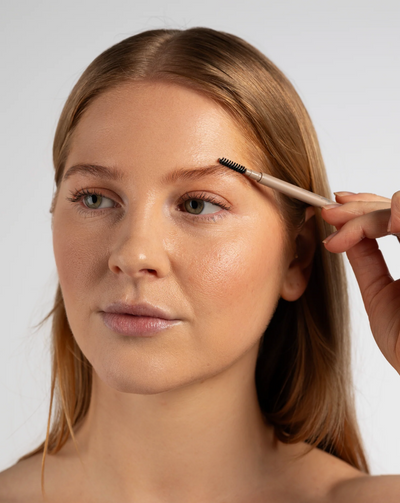 Naturlig udseende køn rødhåret kvinde der bruger Sanzi Beauty FORMING MICRO BROW PEN