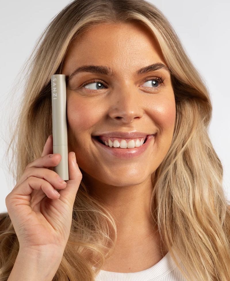 Smilende blonde kvinde med Sanzi mascara 