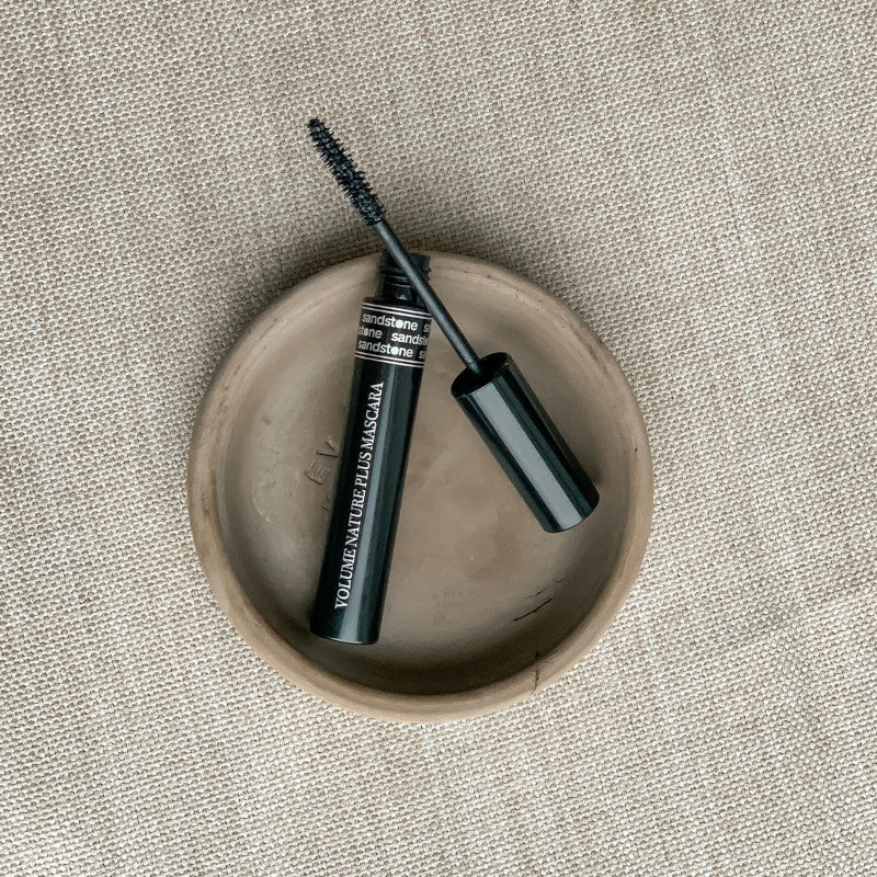 Lerskål på canvas med sort elegant mascara og pen i sort beholder med sirlig sølv skrift. Sandstone Mascara Volume Nature Plus