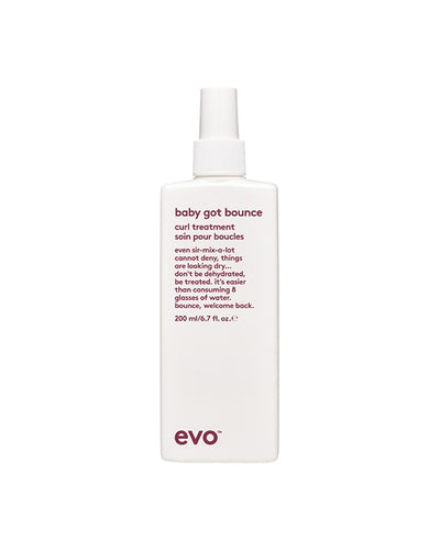 En stilig høj hvid EVO flaske "baby got bounce" curl treatment med bløde former og bordeaux skrift på en ren hvid baggrund.